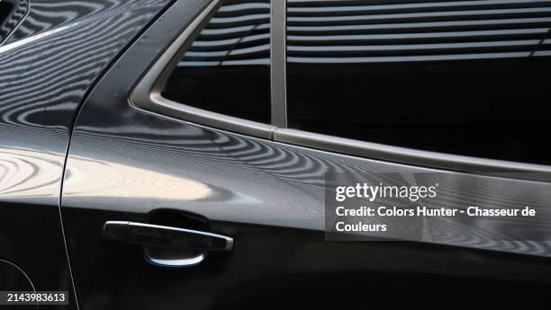 close-up of the rear door with tinted glass of a black car parked in the street in brussels, belgium.
sunlight. natural colors.
no logo or trademark. - sleek black car stock pictures, royalty-free photos & images