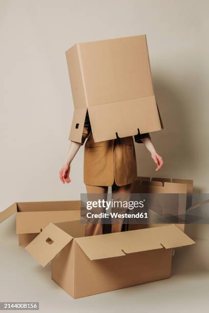 businesswoman hiding in carton box against white background - trapped stock pictures, royalty-free photos & images
