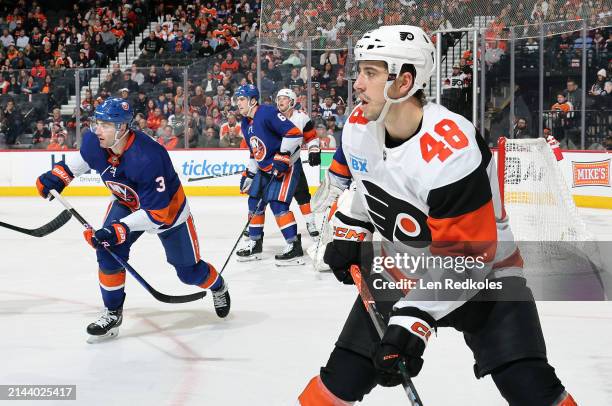 Morgan Frost of the Philadelphia Flyers poised against Adam Pelech # and Ryan Pulock of the New York Islanders at the Wells Fargo Center on April 1,...