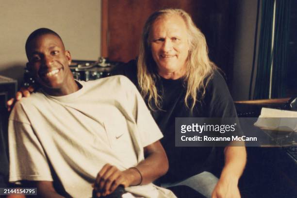 Kevin Garnett, wearing a beige Nike t-shirt and a diamond earring smiles for the camera next to Joe Pytka who is wearing a black t-shirt and jeans...