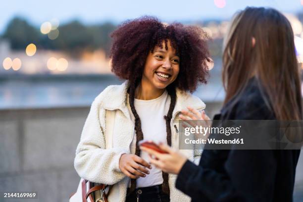 young friends talking with each other at dusk - talking stock pictures, royalty-free photos & images