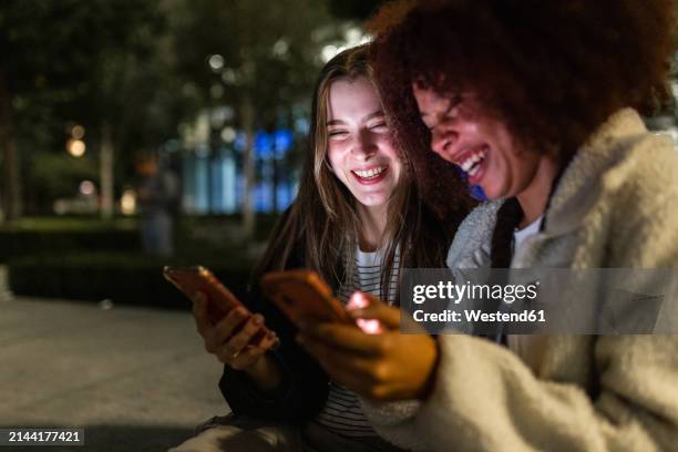 Cheerful Young Friends Using Mobile Phones At Night High-Res Stock ...
