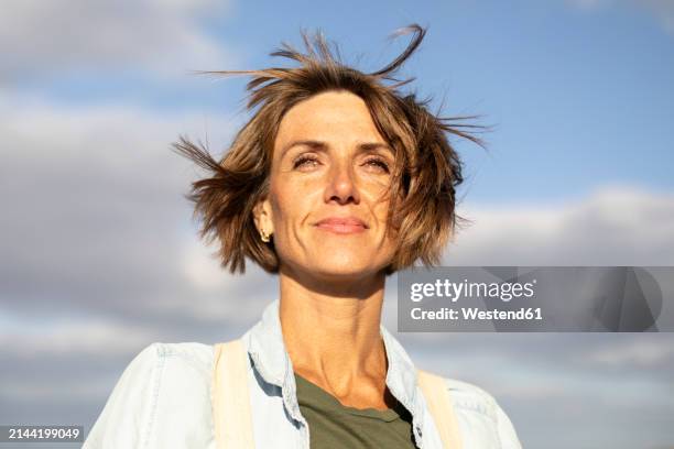 smiling woman with short hair under sky - menschliches alter stock-fotos und bilder