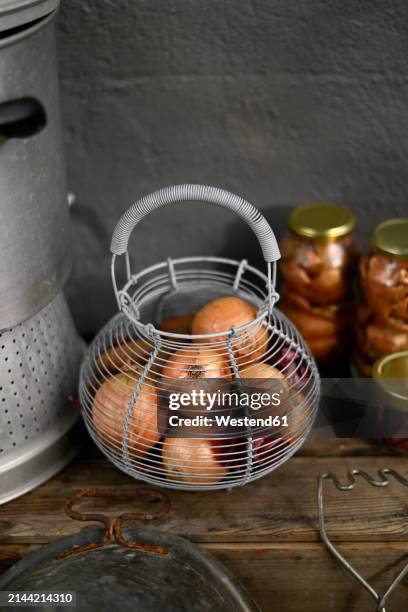 fresh onions in wire basket - westend61 stock-fotos und bilder