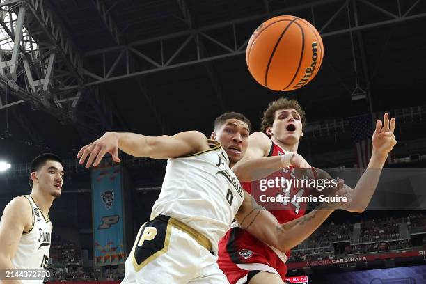 Mason Gillis of the Purdue Boilermakers and Ben Middlebrooks of the North Carolina State Wolfpack battle for a loose ball in the first half in the...