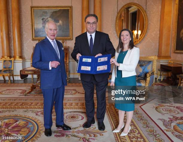 King Charles III is presented with the first bank notes featuring his portrait from the Bank of England Governor Andrew Bailey and Sarah John, the...