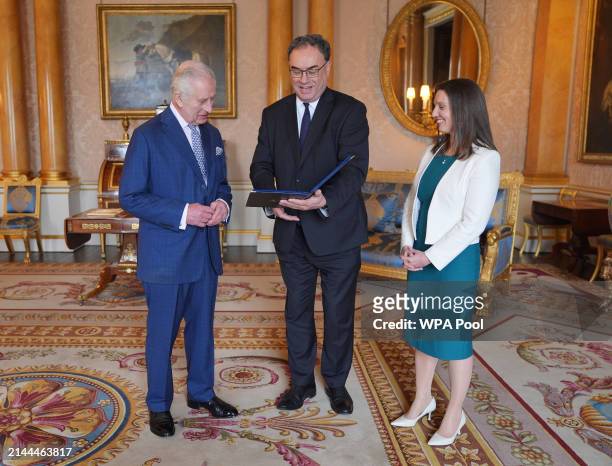 King Charles III is presented with the first bank notes featuring his portrait from the Bank of England Governor Andrew Bailey and Sarah John, the...