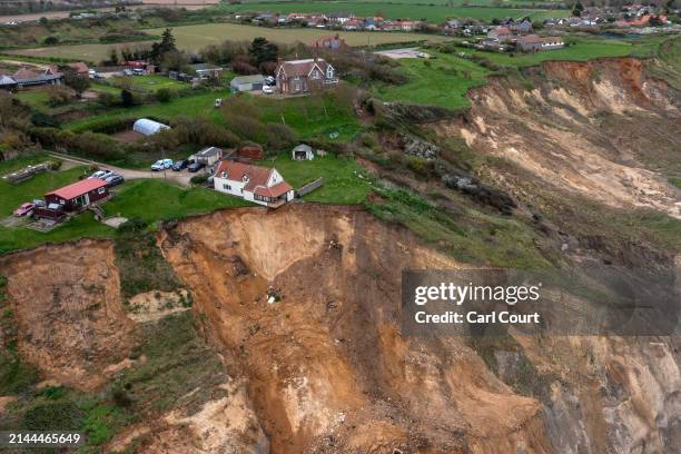 House partially hangs over a cliff edge following rapid coastal erosion, on April 9, 2024 in Trimingham, United Kingdom. Coastal erosion has...