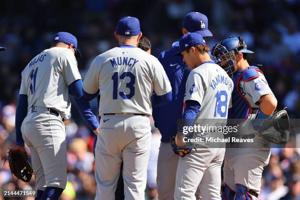 Yoshinobu Yamamoto of the Los Angeles Dodgers talks with pitching coach Mark Prior against the Chicago Cubs during the first inning at Wrigley Field...