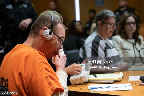James Crumbley reacts to his wife Jennifer Crumbley, mother of Oxford High School mass shooter Ethan Crumbley, as she reads a statement while sitting...
