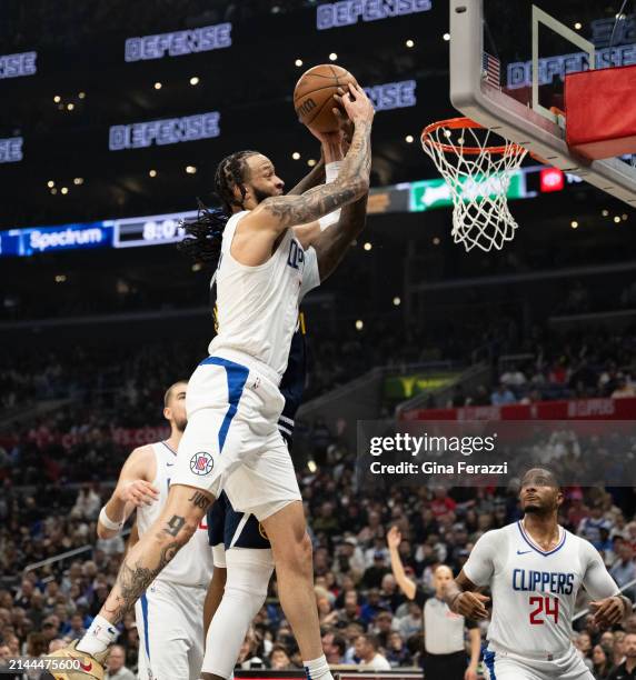 Clippers guard Amir Coffey initiates grabs a rebound from Denver Nuggets guard Kentavious Caldwell-Pope at Crypto.com Arena on April 4, 2024 in Los...