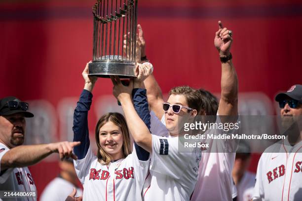 Brianna and Trevor Wakefield hoist the 2004 World Series trophy during pre-game ceremonies before the 2024 Opening Day game against the Baltimore...