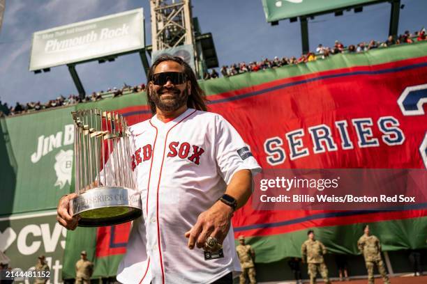 Former outfielder Johnny Damon displays the World Series trophy during a pre-game ceremony in recognition of the 2004 World Series twenty year team...