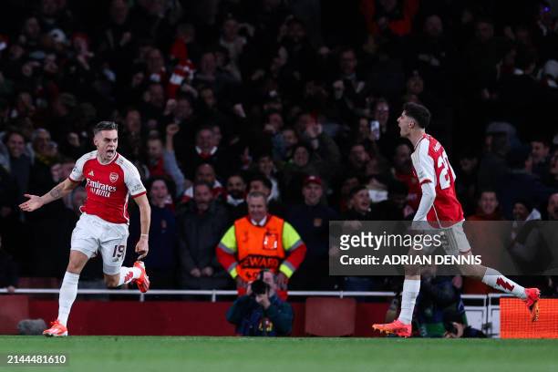 Arsenal's Belgian midfielder Leandro Trossard celebrates after scoring his team second goal during the UEFA Champions League quarter final first-leg...
