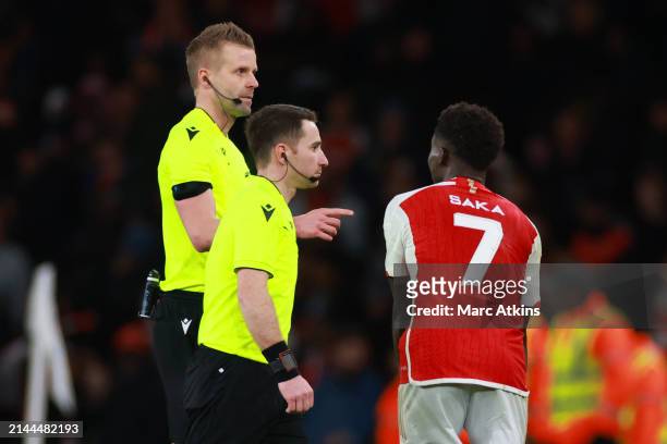 Bukayo Saka of Arsenal confronts Referee Glenn Nyberg at full time during the UEFA Champions League quarter-final first leg match between Arsenal FC...