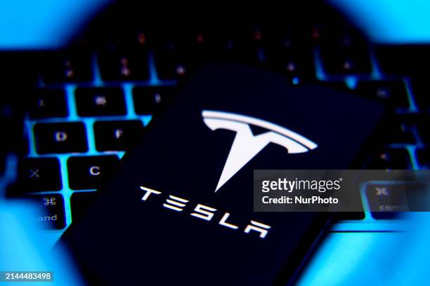 Tesla logo is screened on a mobile phone for illustration photo. Krakow, Poland on April 9th, 2024
