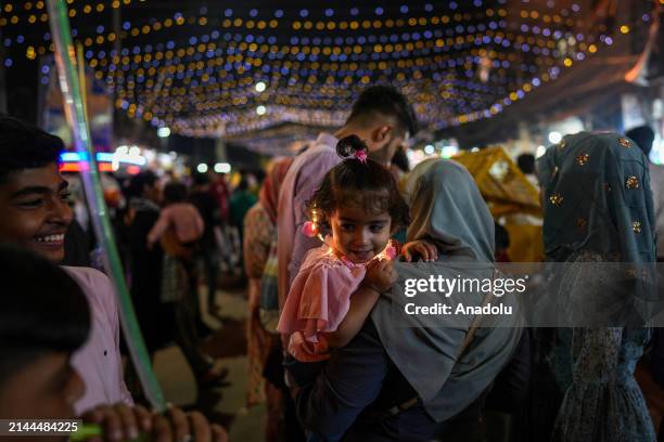 Child smiles as people flock to a bustling marketplace near Jama Masjid as part of Eid Al-Fitr preparations in New Delhi, India on April 09, 2024....