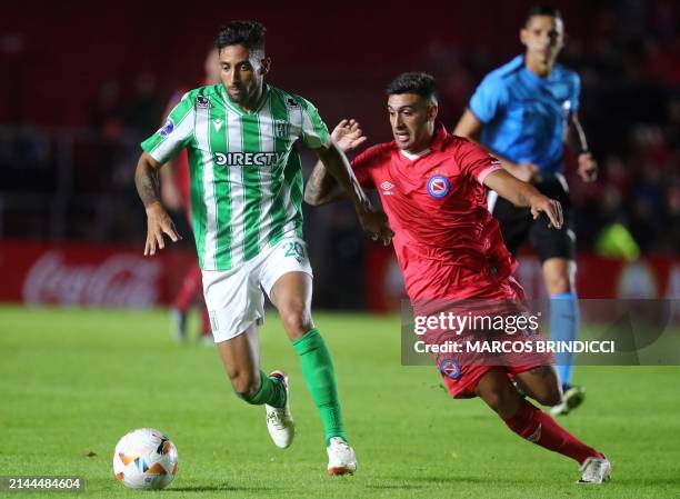 Racing's forward Jonathan Urretaviscaya and Argentinos Juniors' midfielder Franco Moyano fight for the ball during the Copa Sudamericana group stage...