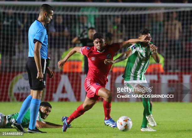 Argentinos Juniors' forward Maxi Romero and Racing's forward Jonathan Urretaviscaya fight for the ball during the Copa Sudamericana group stage first...
