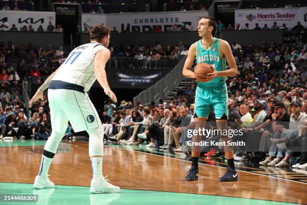 Aleksej Pokusevski of the Charlotte Hornets handles the ball against Luka Doncic of the Dallas Mavericks during the game on April 9, 2024 at Spectrum...