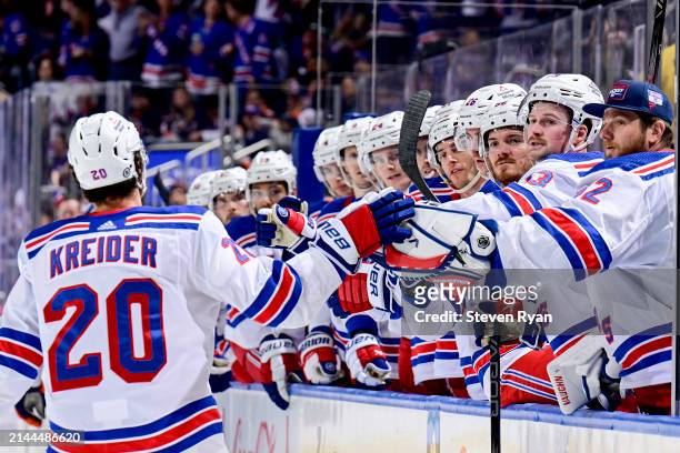 Chris Kreider of the New York Rangers is congratulated by his teammates after scoring a goal against the New York Islanders during the second period...