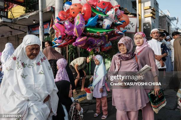 Muslims gather for Eid al-Fitr prayers, marking the end of the holy month of Ramadan, on a street in Jakarta on April 10, 2024.