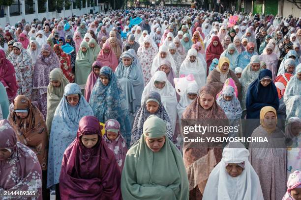 Muslims take part in Eid al-Fitr prayers, marking the end of the holy month of Ramadan, on a street in Jakarta on April 10, 2024.