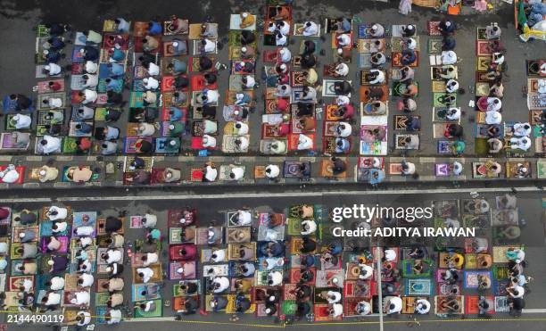 An aerial image shows Muslims attending Eid al-Fitr prayers, marking the end of the holy month of Ramadan, on a street in Bekasi, West Java, on April...