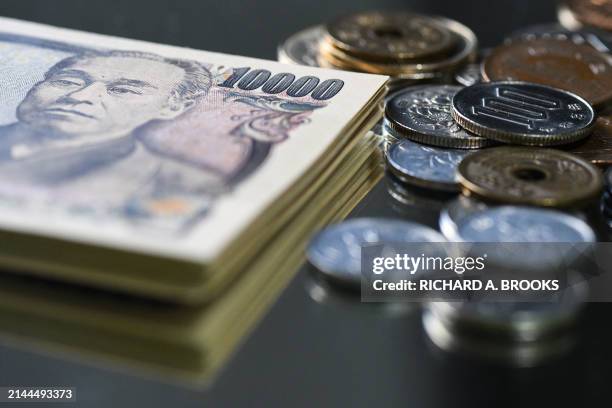 This photo illustration taken on April 10, 2024 shows Japanese yen coins and 10,000 yen notes on display in Tokyo.