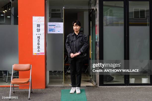 Kim Yong-ho who owns a food and beverages business, poses outside a polling station in Seoul on April 10 after voting for the first time, during the...