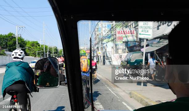 Cyclists are accompanying a man who is driving an electric tricycle during a ride-out protest to the headquarters of the Metro Manila Development...