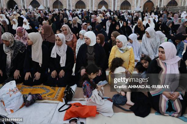 Women pray on the first day of Eid al-Fitr, which marks the end of the holy fasting month of Ramadan, at the Sunni Muslim mosque of Abdul Qader...