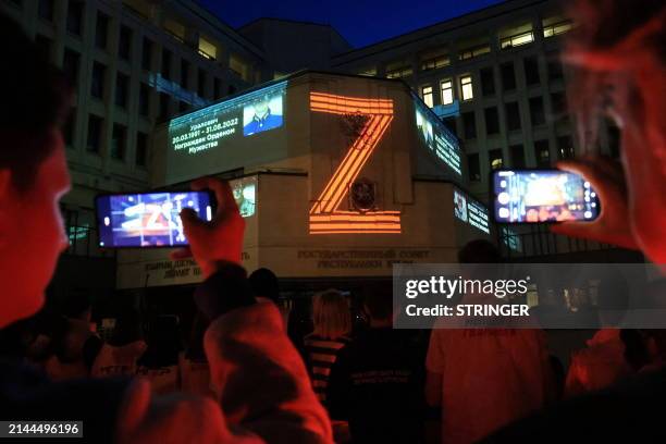 Portraits of Russian service members killed in the ongoing Russian-Ukrainian conflict and the "Z" letter are seen projected onto the State Council...