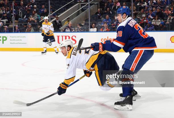 Anthony Beauvillier of the Nashville Predators is hit by Alexander Romanov of the New York Islanders during the first period at UBS Arena on April...