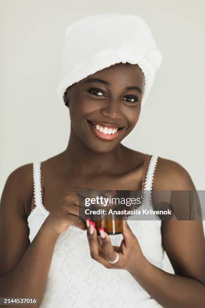 young african - american woman using nourishing face cream. - dark skin tone stock pictures, royalty-free photos & images