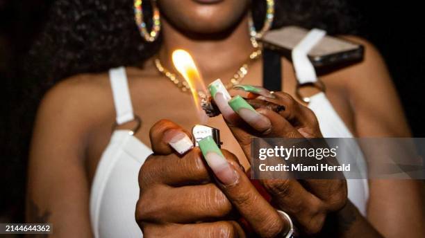 Woman lights a marijuana blunt on Ocean Drive during the fourth week of Spring Break in Miami Beach, Florida, on Saturday, March 25, 2023. In...