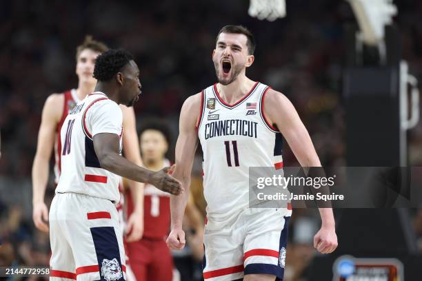 Hassan Diarra and Alex Karaban of the Connecticut Huskies celebrate in the second half against the Alabama Crimson Tide in the NCAA Men's Basketball...