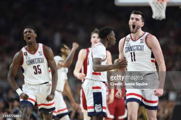 Hassan Diarra and Alex Karaban of the Connecticut Huskies celebrate in the second half against the Alabama Crimson Tide in the NCAA Men's Basketball...