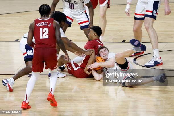 Cam Spencer of the Connecticut Huskies and Rylan Griffen of the Alabama Crimson Tide battle for a loose ball in the second half in the NCAA Men's...