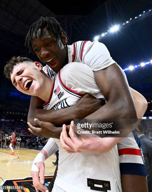 Donovan Clingan and Youssouf Singare of the Connecticut Huskies celebrate their win after the NCAA Men’s Basketball Tournament Final Four semifinal...