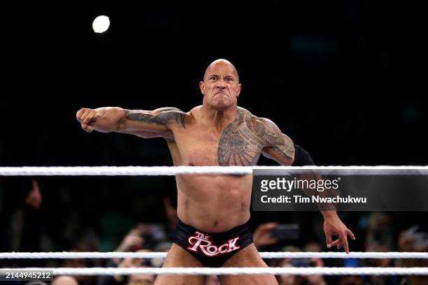 Dwayne "The Rock" Johnson reacts during a tag team fight against Cody Rhodes and Seth "Freakin" Rollins during Night One of WrestleMania 40 at...