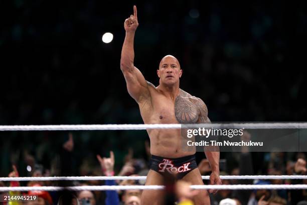 Dwayne "The Rock" Johnson reacts during a tag team fight against Cody Rhodes and Seth "Freakin" Rollins during Night One of WrestleMania 40 at...