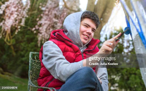 l'adolescente sorridente sta ridipingendo una sedia d'epoca - autismo foto e immagini stock