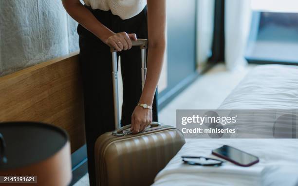 mujer irreconocible que se prepara para salir de una habitación de hotel con una maleta - suite-de-hotel fotografías e imágenes de stock