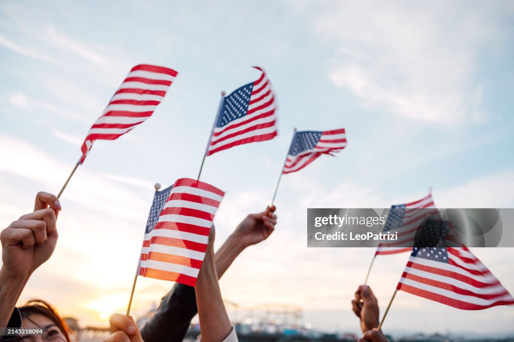 People waving US flags for holidays celebration