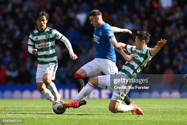 Tom Lawrence of Rangers is tackled by Tomoki Iwata of Celtic during the Cinch Scottish Premiership match between Rangers FC and Celtic FC at Ibrox...