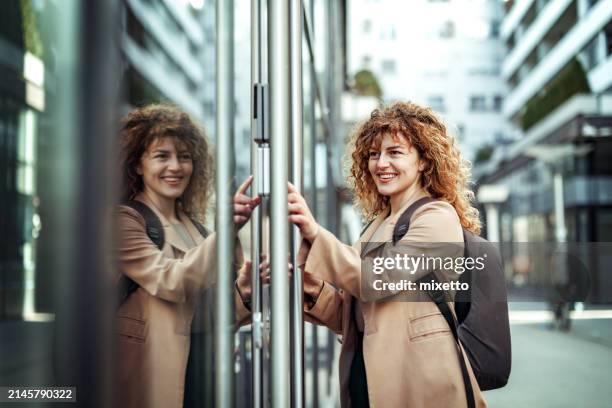 vista laterale di bella giovane donna d'affari che entra nel codice pin davanti alle porte dell'azienda - entrare foto e immagini stock
