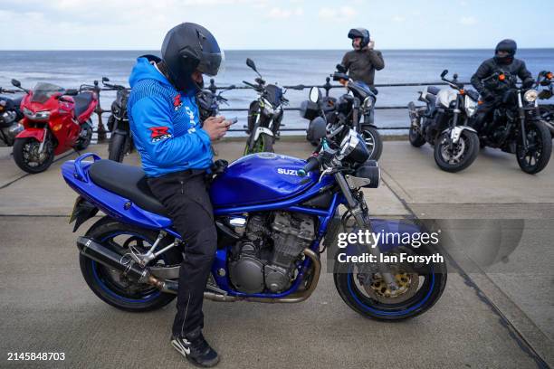 Biker checks his phone in Scarborough after completing a memorial bike ride for Dave Myers of the Hairy Bikers on April 07, 2024 in Scarborough,...