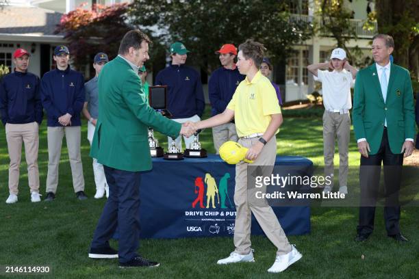 Zachary Schaefer, second overall, of the Boy's 14-15 group shakes hands with Sir Nick Faldo of England during the Drive, Chip and Putt Championship...