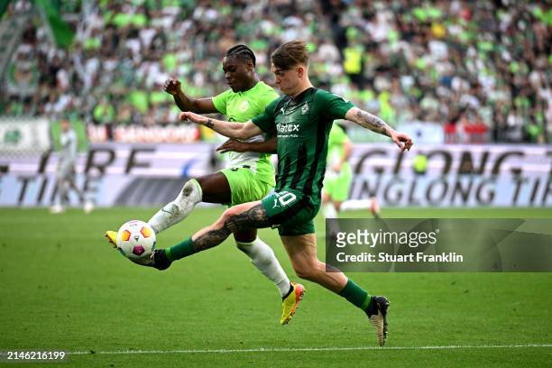 Luca Netz of Borussia Mönchengladbach battles for possession with Ridle Baku of VfL Wolfsburg during the Bundesliga match between VfL Wolfsburg and...